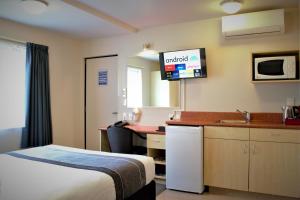 a hotel room with a bed and a desk at Bella Vista Motel Taupo in Taupo