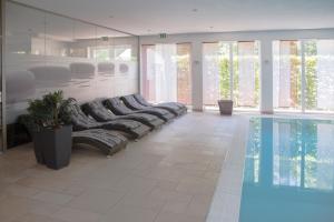 a room with a pool and a row of seats next to a swimming pool at Waldidyll Rabenhorst in Homburg