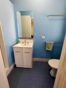 
a bathroom with a toilet, sink, and mirror at Dunsborough Beach Lodge in Dunsborough

