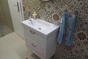 een badkamer met een witte wastafel en een douche bij Kućica u Šumi Privatni smeštaj Užice in Užice +20 foto's