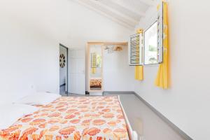a bedroom with a bed and a window at Le Colibri Vert in Le Morne-Vert