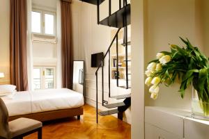 1 dormitorio con 1 cama y un jarrón de flores en Splendor Suite Rome - Suites & Apartments, en Roma