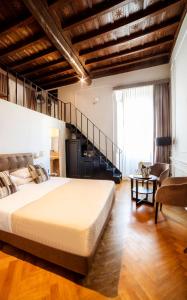 a bedroom with a large bed and a staircase at Splendor Suite Rome - Suites & Apartments in Rome