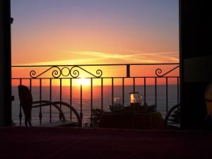 a view of the sunset from the balcony of a restaurant at Hotel Bellavista S'Archittu in S'archittu Cuglieri +35 photos