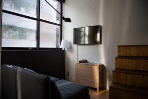 ein Wohnzimmer mit einem Sofa und einem Fenster in der Unterkunft Arcsens Tokyo in Tokio