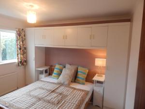a small bedroom with a bed and a window at Two bedroom corporate and family stay with parking in popular location in Cambridge