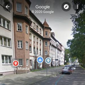 eine Straße mit Schildern an der Seite eines Gebäudes in der Unterkunft KOŁOBRZEG Jana Pawła 19 mieszkanie 2 pokojowe in Kołobrzeg