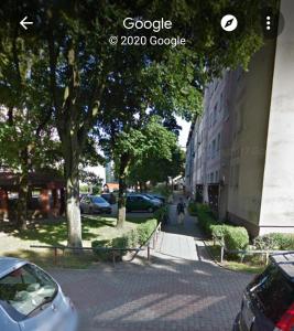 eine Straße mit Autos neben einem Gebäude in der Unterkunft KOŁOBRZEG Jana Pawła 19 mieszkanie 2 pokojowe in Kołobrzeg + 3 Fotos