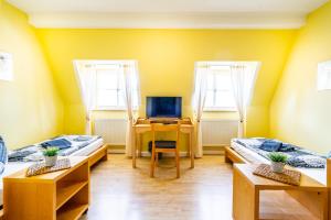 a room with two beds and a desk with a computer at Stiftung soziale Projekte Meißen in Meißen