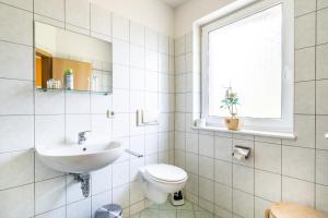 La salle de bains est pourvue d'un lavabo, de toilettes et d'une fenêtre. dans l'établissement Stiftung soziale Projekte Meißen, à Meissen