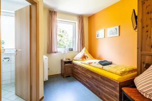 ein kleines Schlafzimmer mit einem Bett und einem Fenster in der Unterkunft Stiftung soziale Projekte Meißen in Meißen