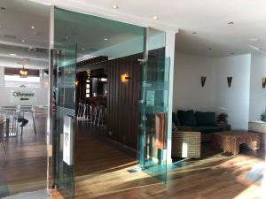 a glass hallway with a couch and a table at HOTEL V.CIUDAD in Aranda de Duero