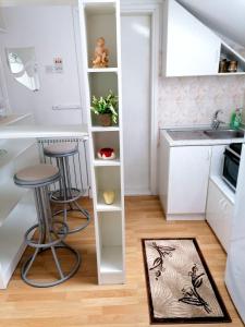 a small kitchen with two stools and a sink at Apartman Slavica in Nova Varoš