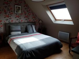 1 dormitorio con cama y ventana. en Ker Kistin, en Fouesnant