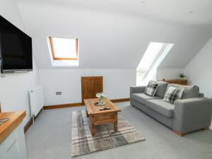 a living room with a couch and a coffee table at Highfield Barn in Wisbech