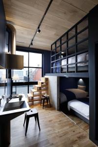 東京的住宿－Arcsens Tokyo，一间卧室配有两张双层床、一张桌子和一张桌子
