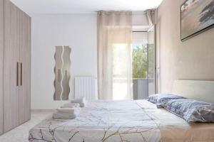 een slaapkamer met een groot bed en handdoeken bij [FREE PARKING] Appartamento 5 STELLE elegante con suite in Livorno