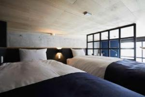 1 Schlafzimmer mit 2 Betten und einem großen Fenster in der Unterkunft Arcsens Tokyo in Tokio