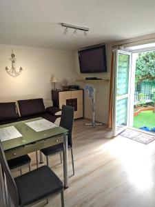 a living room with a couch and a table and a tv at APARTAMENT BERMUDY in Świnoujście