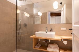 a bathroom with a sink and a shower at Weingut Schmid Oberrautner Apartment Suites in Bolzano