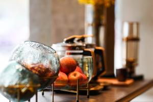 una mesa con dos tazones de manzanas y un exprimidor en Kasion Pugis Hotel, en Yiwu