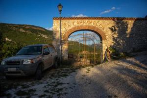 um carro estacionado em frente a um arco de pedra em La Caprareccia em Fiumata
