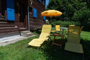 a group of chairs and a table with an umbrella at Chalet le Petit Tremplin in Leysin