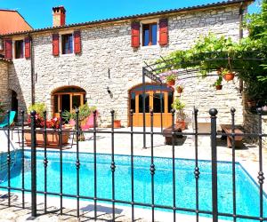 a house with a fence around a swimming pool at Villa Rustica in Buje