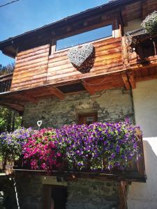 a building with a balcony filled with flowers at Maison Le Cler in Valtournenche