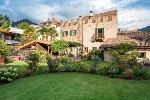 a large house with a garden in the yard at Weingut Schmid Oberrautner Apartment Suites in Bolzano
