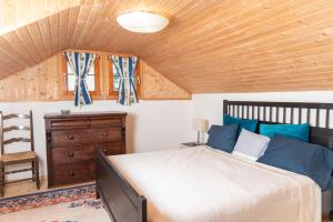 - une chambre avec un lit et un plafond en bois dans l'établissement Chalet le Petit Tremplin, à Leysin