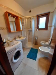 ein Badezimmer mit einer Waschmaschine und einem Waschbecken in der Unterkunft Appartamento al Pelmo in Villanova