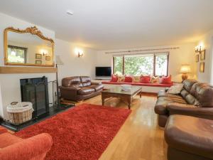a living room with leather furniture and a fireplace at 1 Cherry Tree Cottage in Millom