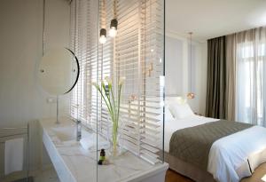 a bedroom with a bed and a sink and a mirror at Marpessa Hotel & Spa in Agrinion