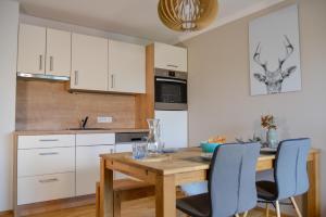 a kitchen with a wooden table and blue chairs at Alpine Appartement Top 8 by AA Holiday Homes in Tauplitz
