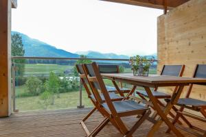 a wooden table and chairs on a deck with a view at Alpine Chalet Pia Top 5 by AA Holiday Homes in Bad Mitterndorf +2 photos