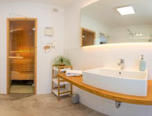 ein Bad mit einem Waschbecken und einem Spiegel in der Unterkunft Alpine Appartement Top 2 by AA Holiday Homes in Tauplitz