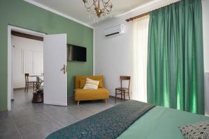 a bedroom with a bed and a chair and a window at Case Barbera Vetriera in Palermo