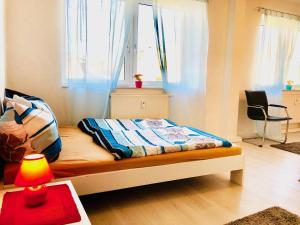 a bedroom with a bed with a lamp and a table at #WORLD Monteurzimmer in Schkeuditz