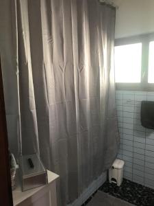 una tenda da doccia in un bagno con finestra di Genzianella a Quinto