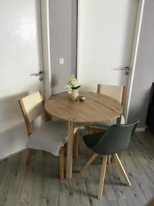 una mesa de madera y sillas en una habitación en Apartment am Park -Calluna en Schneverdingen
