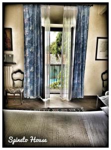 een slaapkamer met een bed en een raam met gordijnen bij SPINETO HOUSE in Spineto Scrivia
