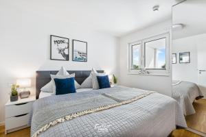 1 dormitorio con 1 cama grande con almohadas azules en MeerLeben en Olpenitz