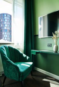 a green chair sitting in front of a window at WIDE Hotel in Copenhagen