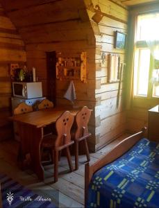 Habitación con mesa de madera en una cabaña en Willa Blanca Zakopane, en Zakopane