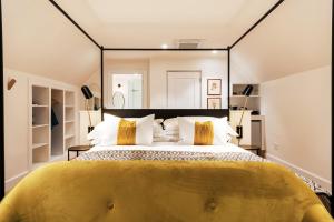 a bedroom with a large bed with yellow pillows at Fairview House in The Crags