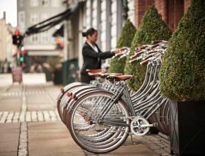 a man sitting on a bench next to a row of bicycles at WIDE Hotel in Copenhagen