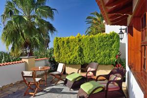 eine Terrasse mit Stühlen, einem Tisch und einer Hecke in der Unterkunft Villa Mary in Tazacorte