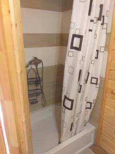 a shower curtain in a bathroom with a bath tub at Apartamenty Lawenda in Wrzosowo