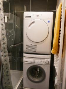 uma máquina de lavar e secar roupa na casa de banho em Maison familiale, 15couchages, de charme au cœur de la Bretagne - 20 min de Vannes em Lizio